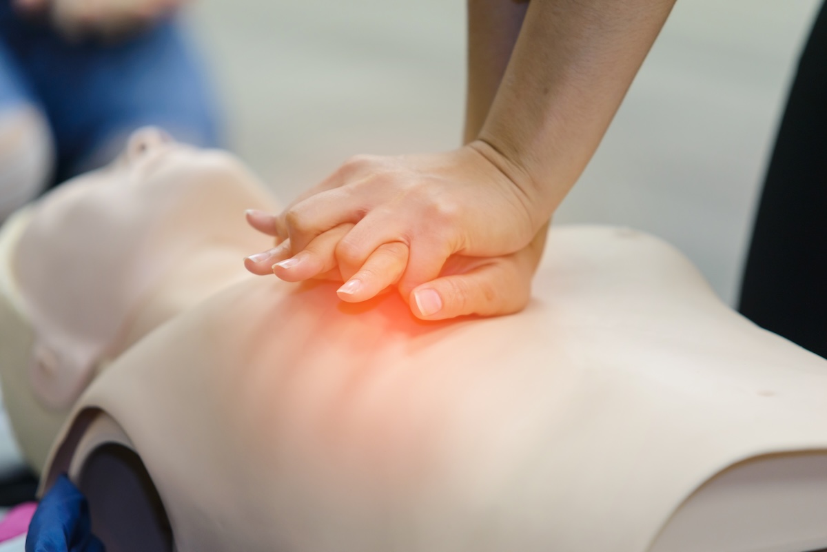Hands performing adult CPR compressions during certification training in Cary, NC
